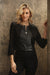 Woman wearing a black zip up cropped jacket with faux leather panels and 3/4 sleeves from Joseph Ribkoff