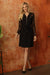 Woman wearing a black shirt dress with lace sleeves and self tie belt from Joseph Ribkoff