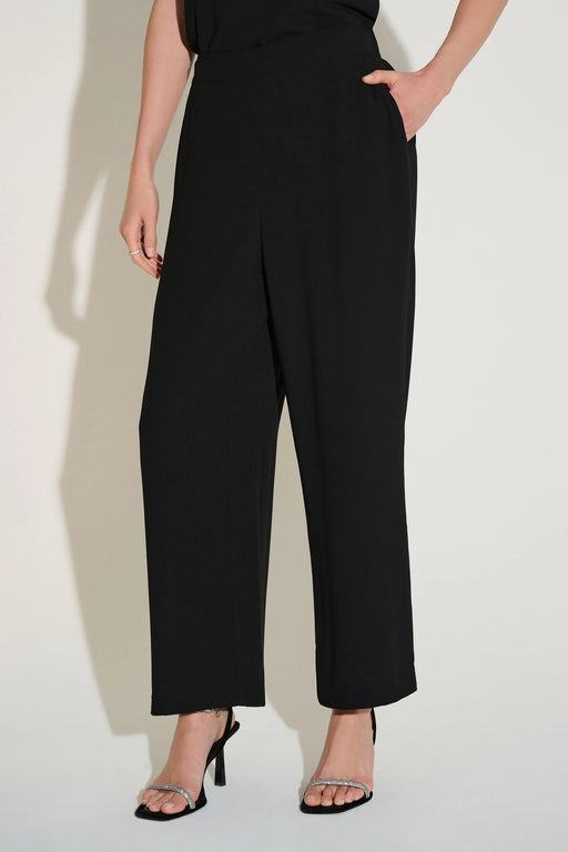 Model wearing a black solid color straight leg ankle length pant with side pockets from Joseph Ribkoff