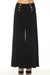 Woman wearing a black flared sailor pants with button details from Joseph Ribkoff