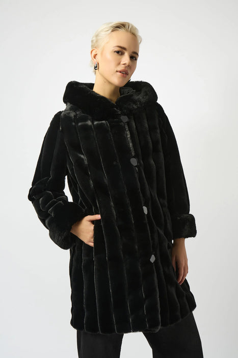 Woman wearing a black reversible hooded quilted faux fur coat