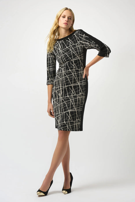 Woman wearing a black and white dress with abstract lines pattern, boat neck, and 3/4 sleeves