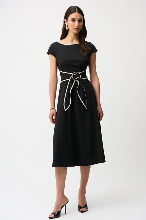 Woman wearing a black midi dress with sash and buckle detail from Joseph Ribkoff