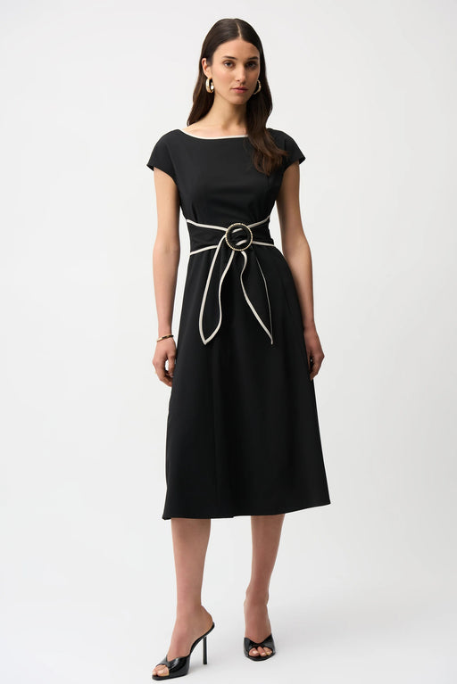 Woman wearing a black midi dress with sash and buckle detail from Joseph Ribkoff
