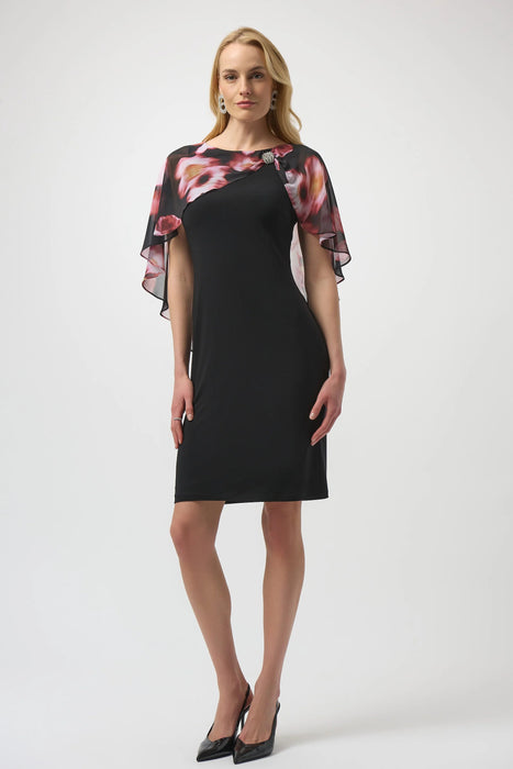 Woman wearing a black dress with a floral chiffon cape