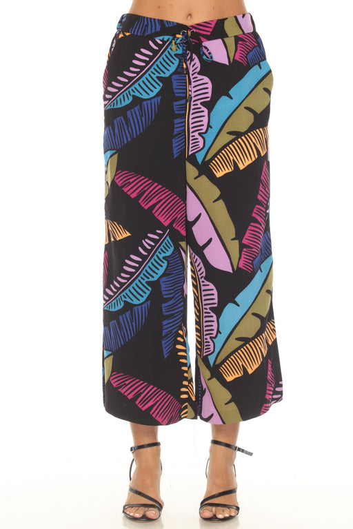 Woman wearing a black culotte pants with colorful tropical leaf print from Joseph Ribkoff