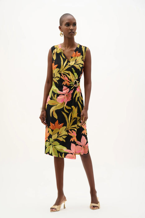 Woman wearing a black tropical floral print wrap dress with sleeveless V-neck design and waist buckle detail, styled for summer elegance.