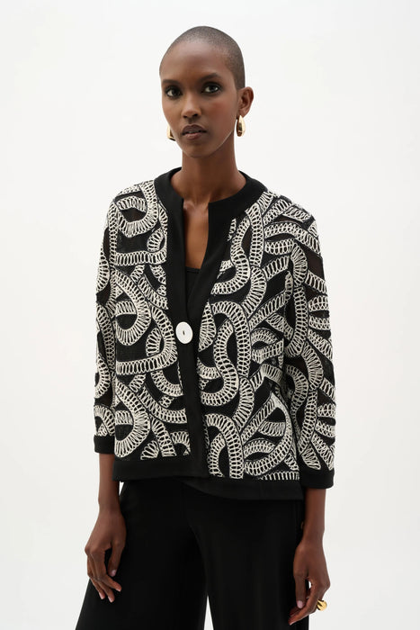 Woman wearing a black mesh swing jacket with white abstract embroidery and 3/4 sleeves from Joseph Ribkoff