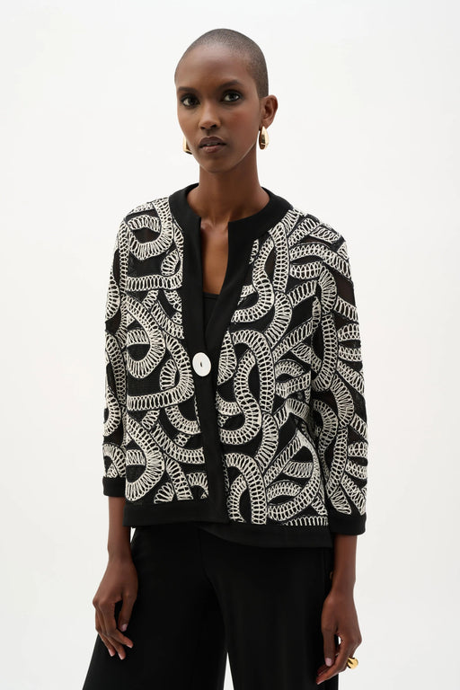Woman wearing a black mesh swing jacket with white abstract embroidery and 3/4 sleeves from Joseph Ribkoff