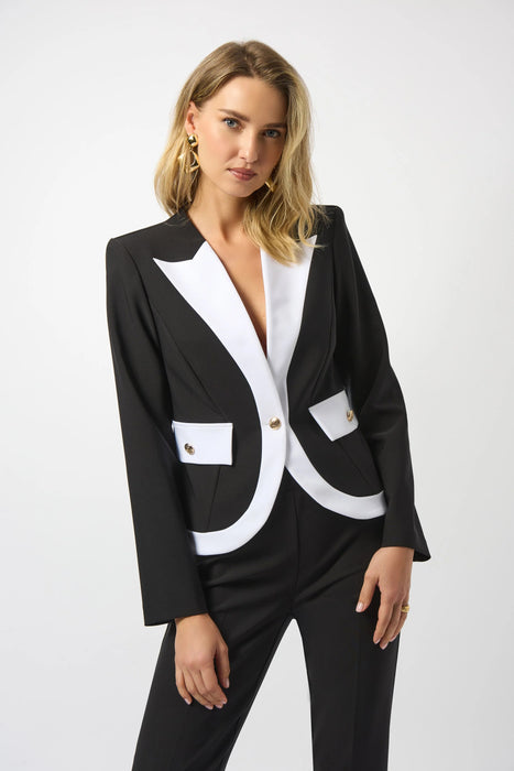 Woman wearing a black and white blazer jacket with v-neck and long sleeves