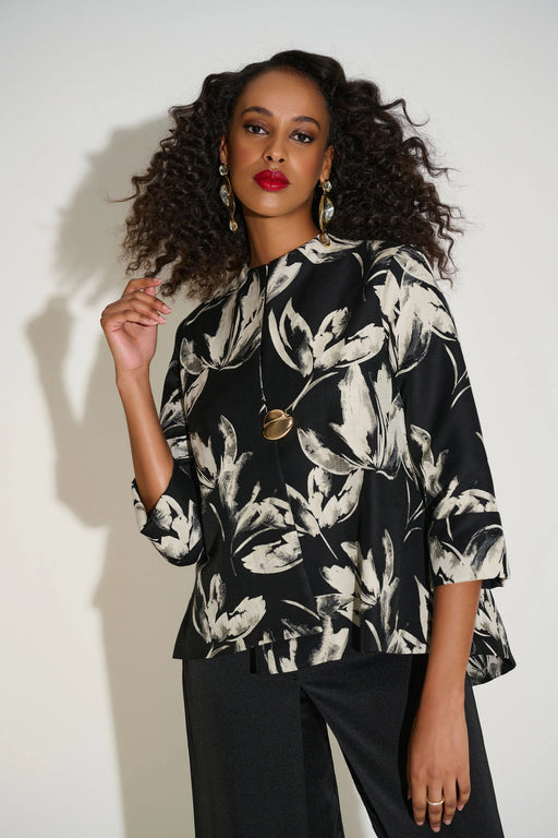 Woman wearing a black and white floral jacket with trapeze silhouette