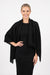 Woman wearing a black pleated shawl with fringe edges from Joseph Ribkoff