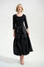 Woman wearing a black 3/4 sleeve dress with pleated midi taffeta skirt from Joseph Ribkoff