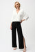 Woman wearing a black wide leg pull on pants with knee-length side slit from Joseph Ribkoff