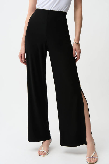 Woman wearing a black wide leg pull on pants with knee-length side slit from Joseph Ribkoff