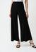 Woman wearing silky knit high-waist wide leg pants with front pintuck seams, styled for office wear, travel, business casual outfits, or contemporary chic fashion.