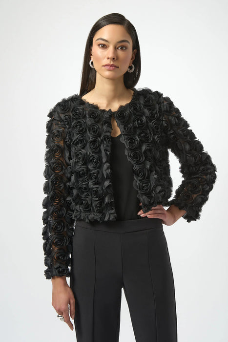 Woman wearing a black bolero jacket with rosette all over from Joseph Ribkoff