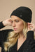 Woman wearing black sequined knitted beanie from Joseph Ribkoff
