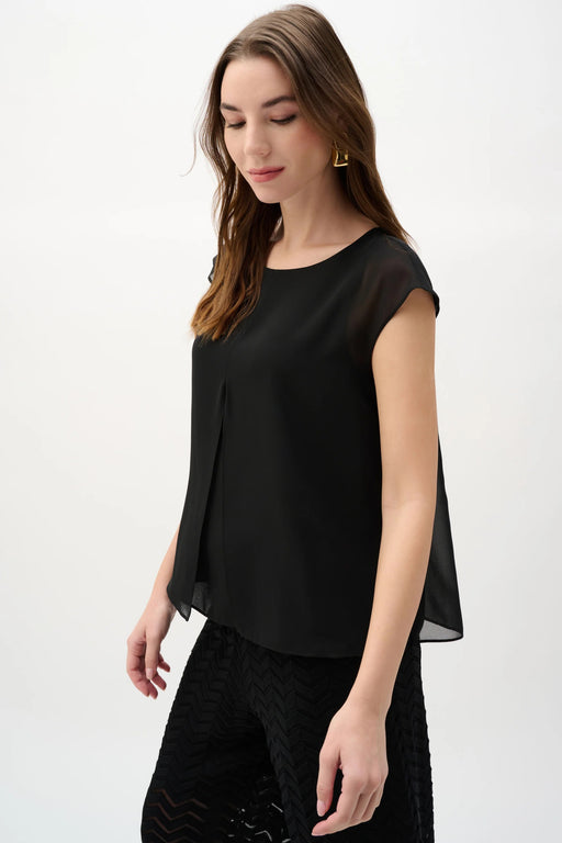 Woman wearing Joseph Ribkoff black short sleeve chiffon pleated top styled for office wear, evening dinner, business casual, and elegant everyday outfits.