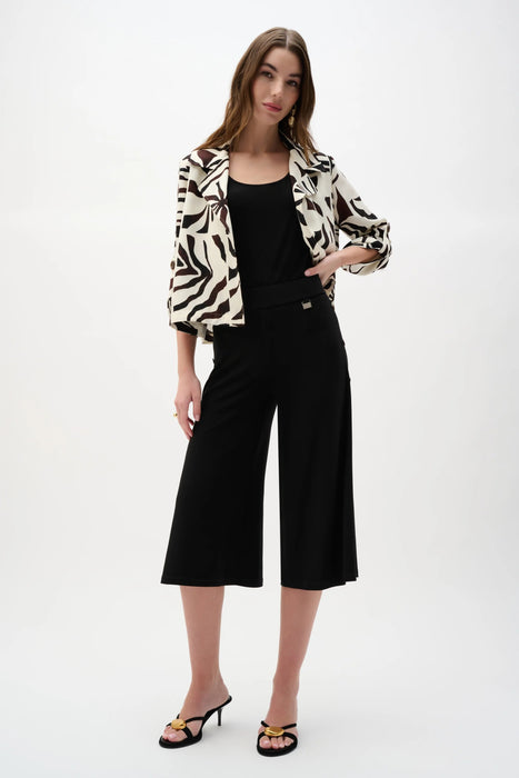 Woman wearing a black Joseph Ribkoff silky knit culotte pants for elegant office outfit