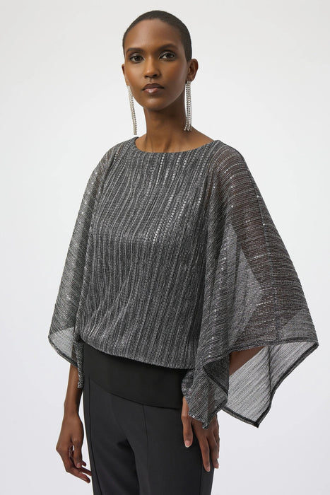Woman wearing a sequined metallic layered top with poncho sleeves