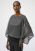 Woman wearing a sequined metallic layered top with poncho sleeves