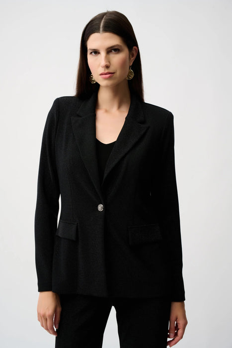 Woman wearing a black sparkling fitted blazer jacket with long sleeves