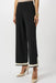 Woman wearing a black wide leg knit pant with contrast trim on the hem