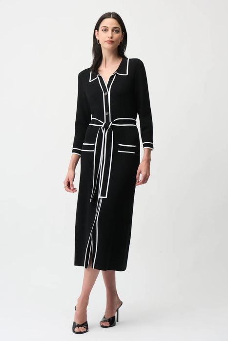 Woman wearing a black knitted midi shirt dress with white trim on the edges and a self-tie belt from Joseph Ribkoff