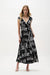 Woman wearing a black and vanilla conversational print fit and flare midi dress with wrap-style bodice and contrast trim, styled for an elegant modern look