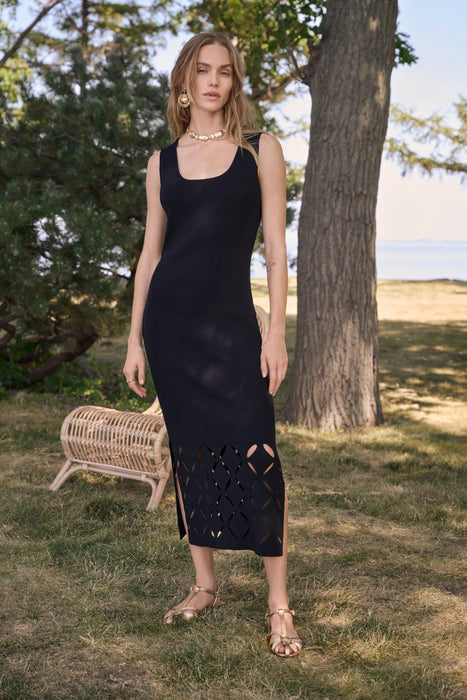 Woman wearing a black sleeveless viscose sweater knit midi dress with a geometric cutout hem and fitted silhouette.
