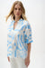 Woman wearing Joseph Ribkoff geometric print puff sleeve top for office workwear outfit