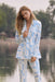 Woman wearing a blue and beige geometric printed double breast blazer jacket with long sleeves from Joseph Ribkoff