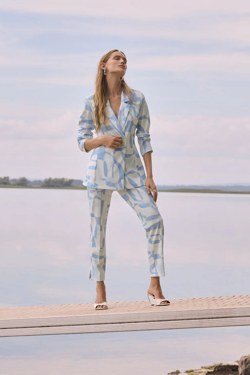 Woman wearing a blue and beige geometric printed straight ankle pants with pull on waistband from Joseph Ribkoff