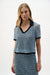 Woman wearing Joseph Ribkoff blue and black polo collar stripe boxy top styled for resort wear, vacation outfits, casual outings, and summer chic looks.