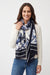 Woman wearing a blue floral and abstract patterned scarf with fringe edges from Joseph Ribkoff