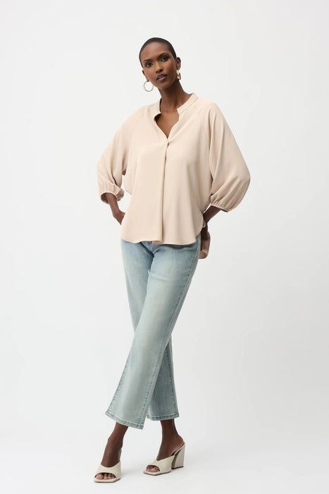 Woman wearing Joseph Ribkoff boxy top with mandarin collar, featuring a relaxed silhouette, soft drape fabric, and elegant minimalist design for modern chic styling.