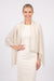 Woman wearing a beige pleated shawl with fringe edges from Joseph Ribkoff