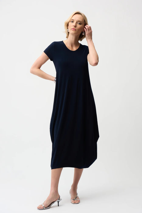 Woman wearing a navy blue solid color midi dress with scoop neck, short sleeves and midi length from Joseph Ribkoff