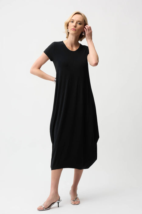Woman wearing a black solid color midi dress with scoop neck, short sleeves and midi length from Joseph Ribkoff