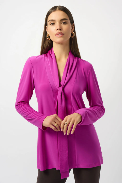 Woman wearing a purple blouse with pussy bow and long sleeves