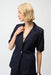 Woman wearing dark blue denim blazer jacket in dark wash with front pockets and puff sleeves from Joseph Ribkoff