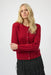 Woman wearing a red cashmere cardigan with rhinestone button front and long sleeves from Joseph Ribkoff