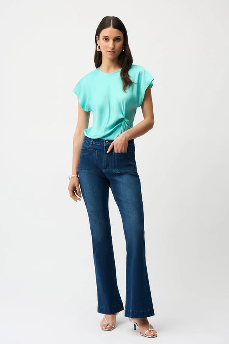 Woman wearing a medium wash blue denim jeans with front patch pockets and flared leg from Joseph Ribkoff
