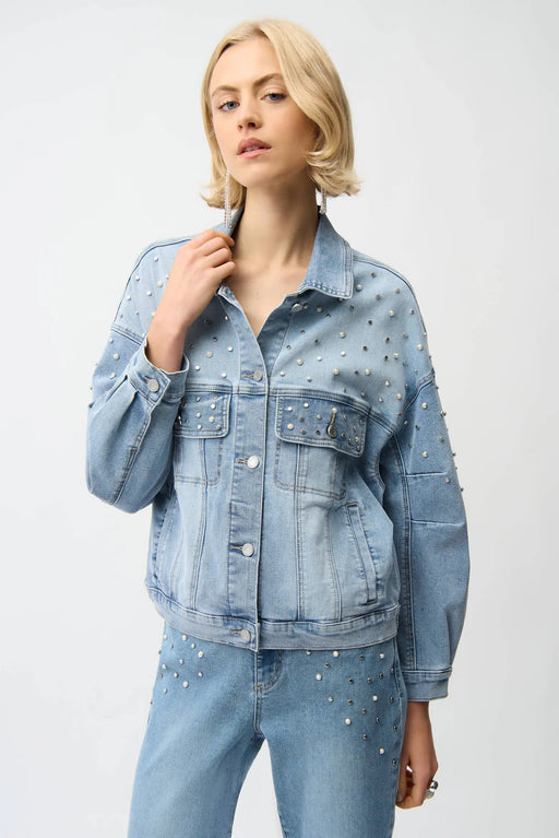 Woman wearing a light blue denim jacket with pearl and stud embellishments from Joseph Ribkoff