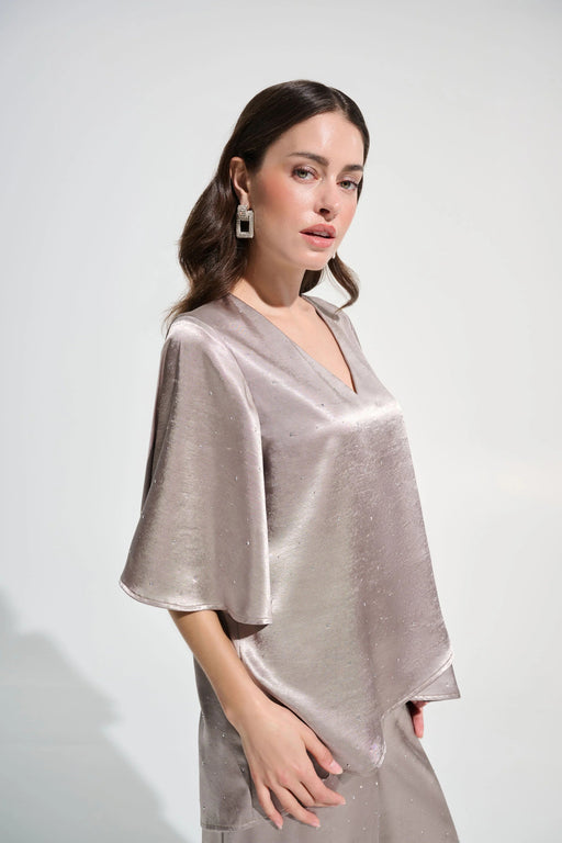 Woman wearing a gray satin top with rhinestone embellishments and v-neck from Joseph Ribkoff