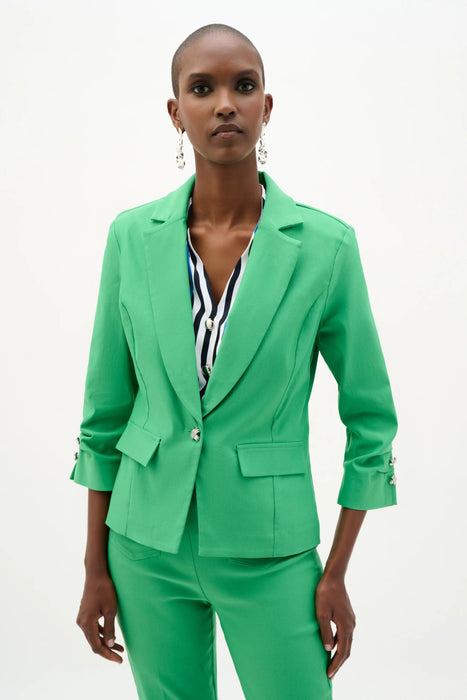 Woman wearing a fitted blazer with a statement button closure, tailored silhouette, and structured lapels for a polished and modern look.