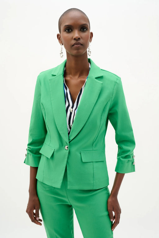 Woman wearing a fitted blazer with a statement button closure, tailored silhouette, and structured lapels for a polished and modern look.