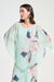 Woman wearing Joseph Ribkoff chiffon floral print poncho top styled for resort wear, special occasions, weddings, and elegant evening outfits.