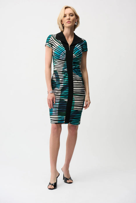 Woman wearing a green and black geometric striped sheath dress with zip front and cap sleeves from Joseph Ribkoff